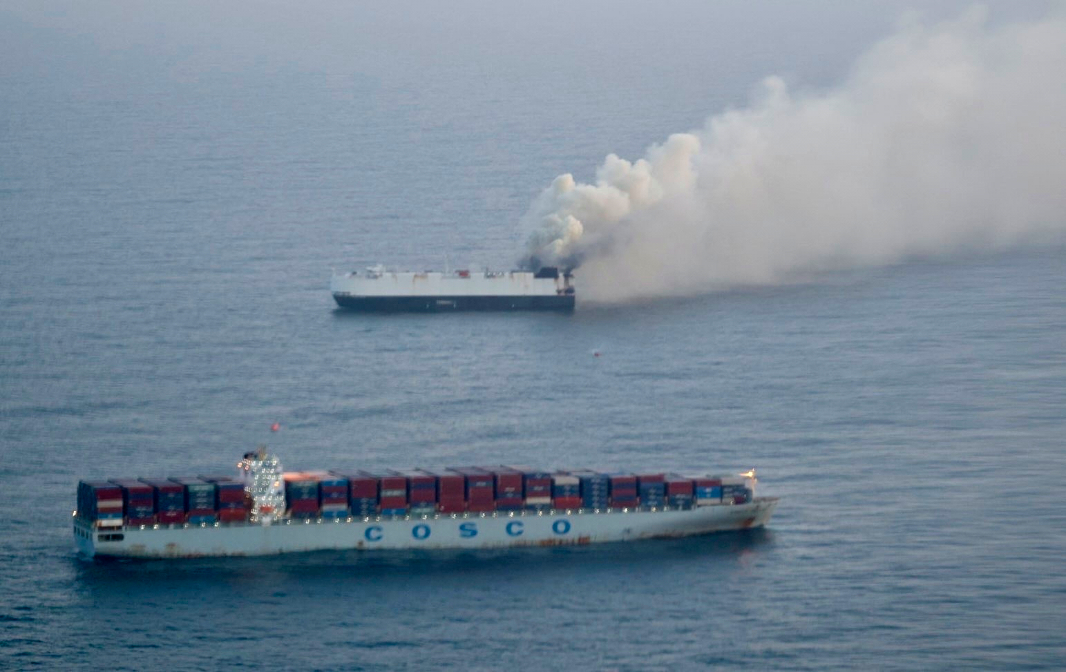 Cargo ship on fire at sea.