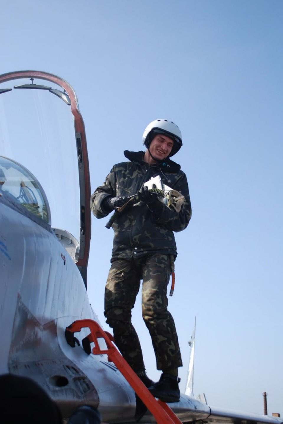 Pilot next to fighter jet.