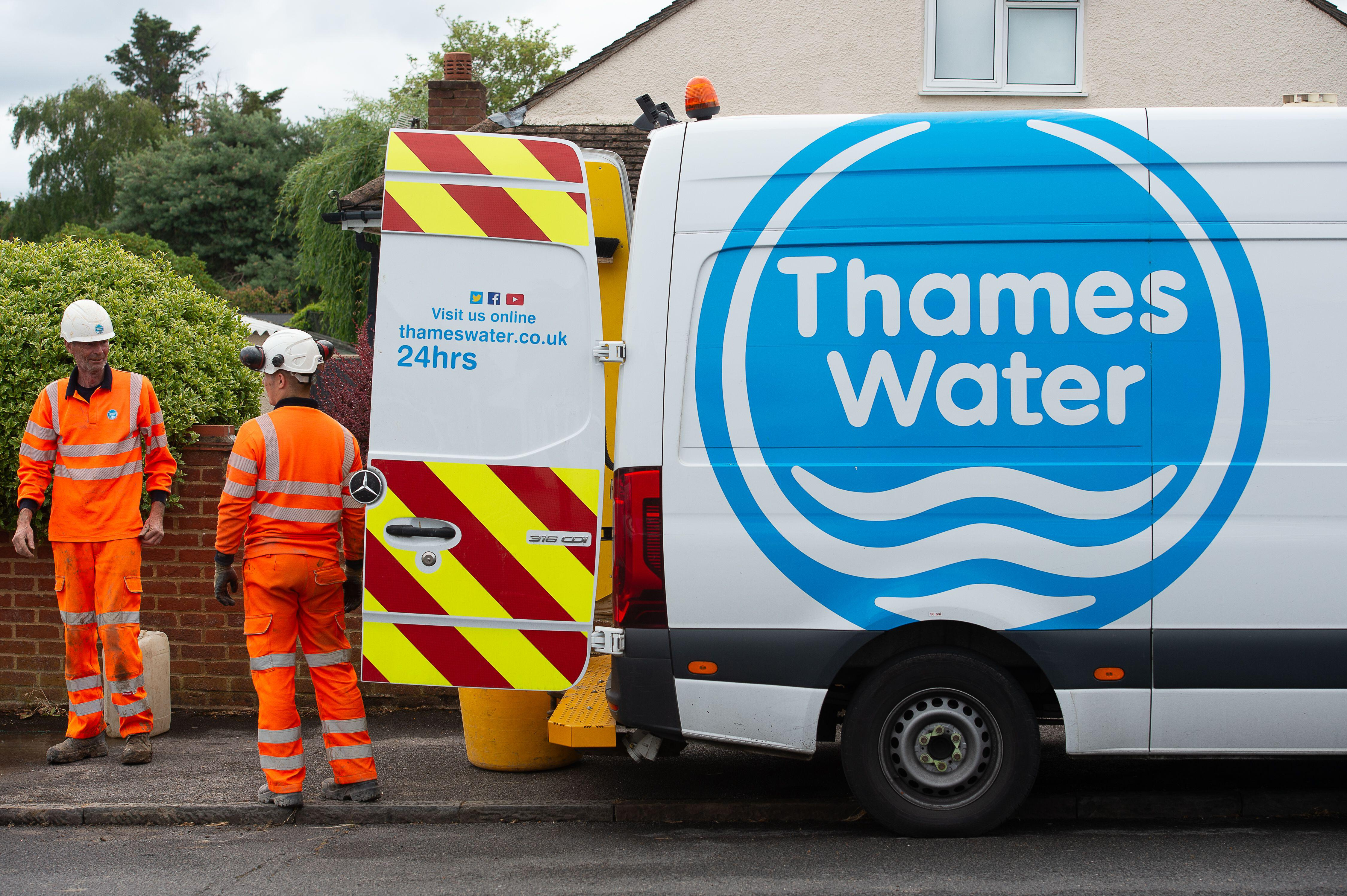 Two Thames Water workers repairing a leaking pipe.