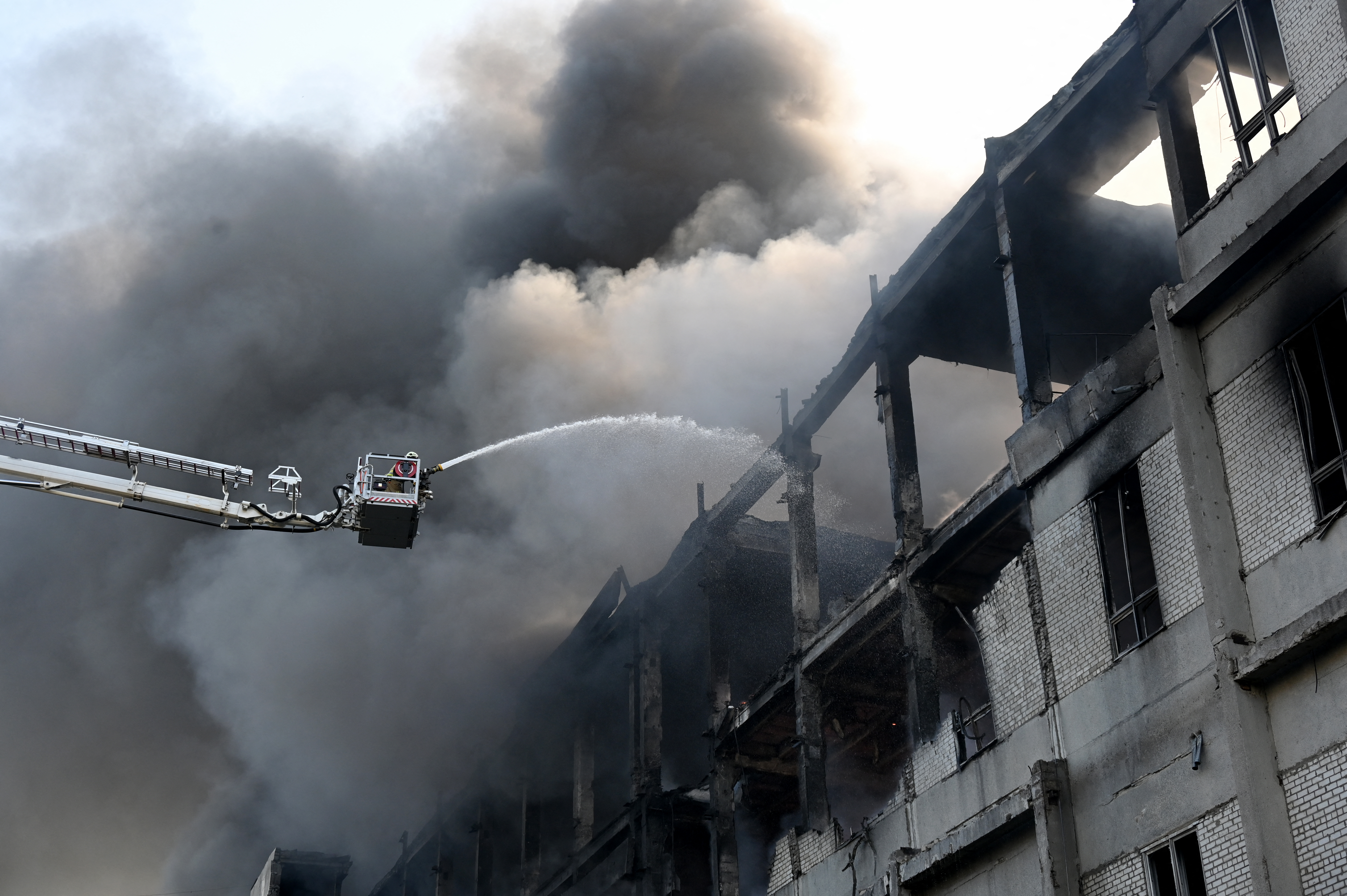 Firefighters extinguishing a fire at a damaged building.