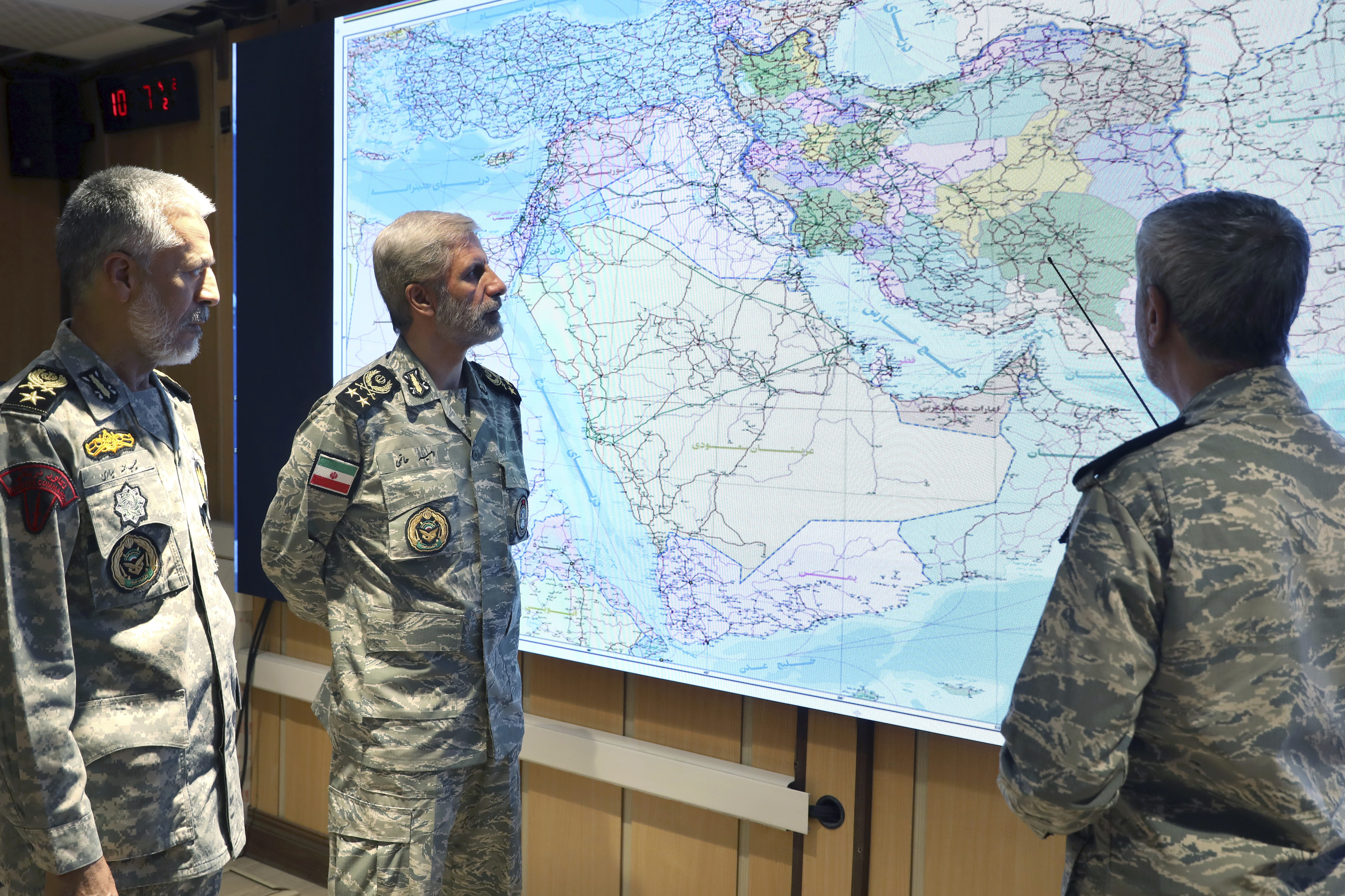 Iranian military officials reviewing a map of the Middle East.