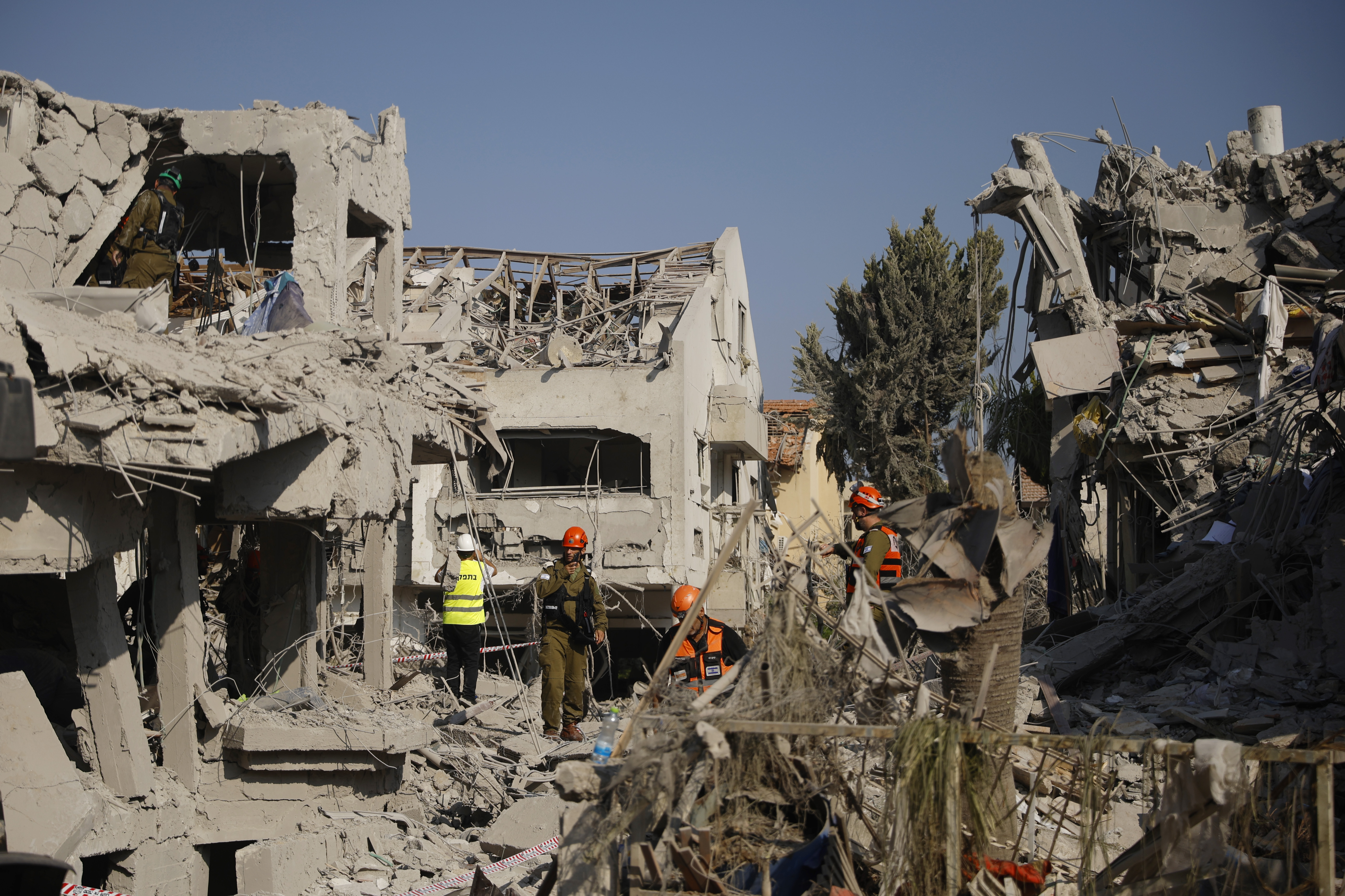 Emergency workers amidst rubble in the aftermath of a missile strike.