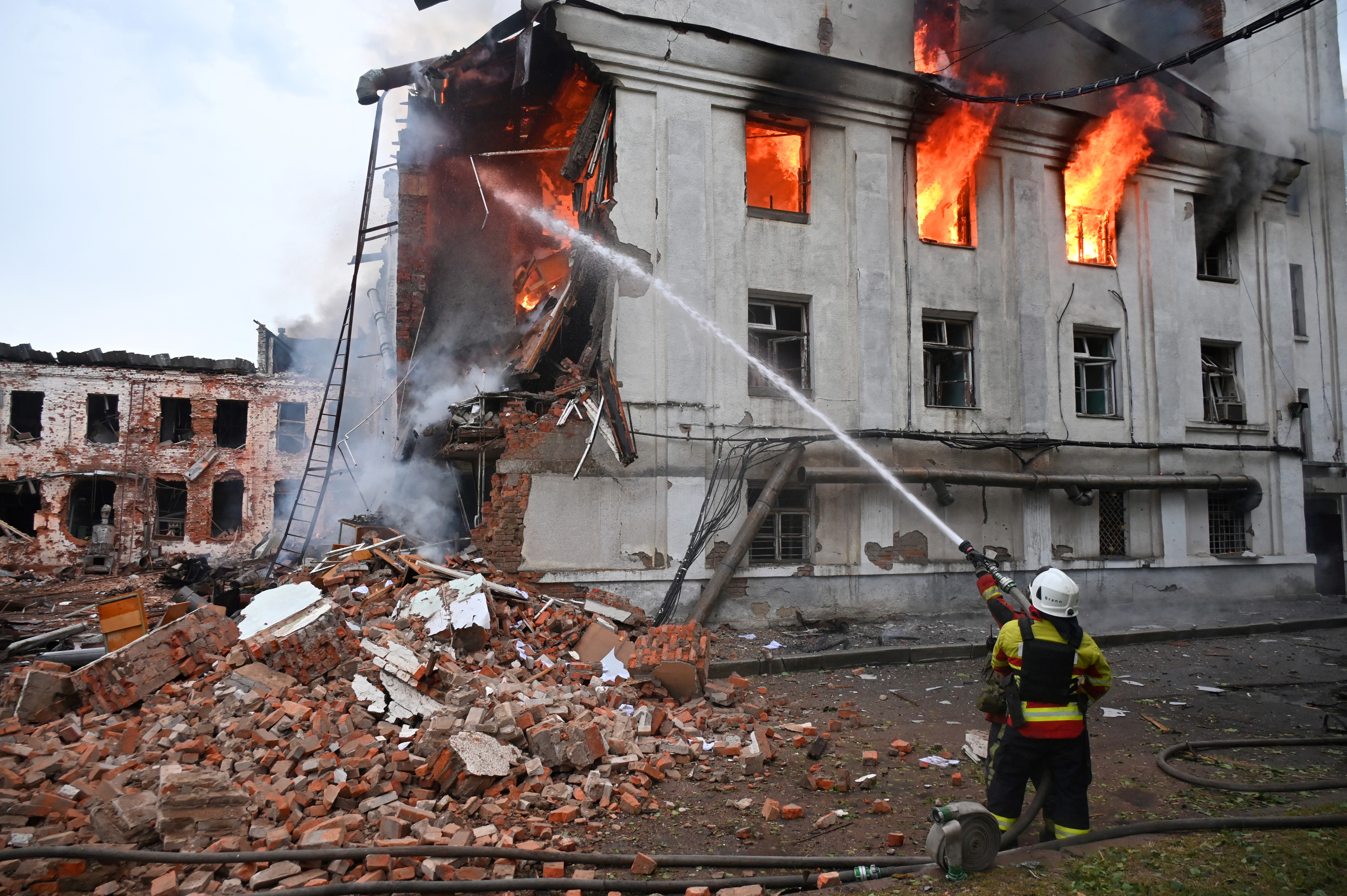 Firefighter extinguishing a fire at a damaged building in Kharkiv, Ukraine.