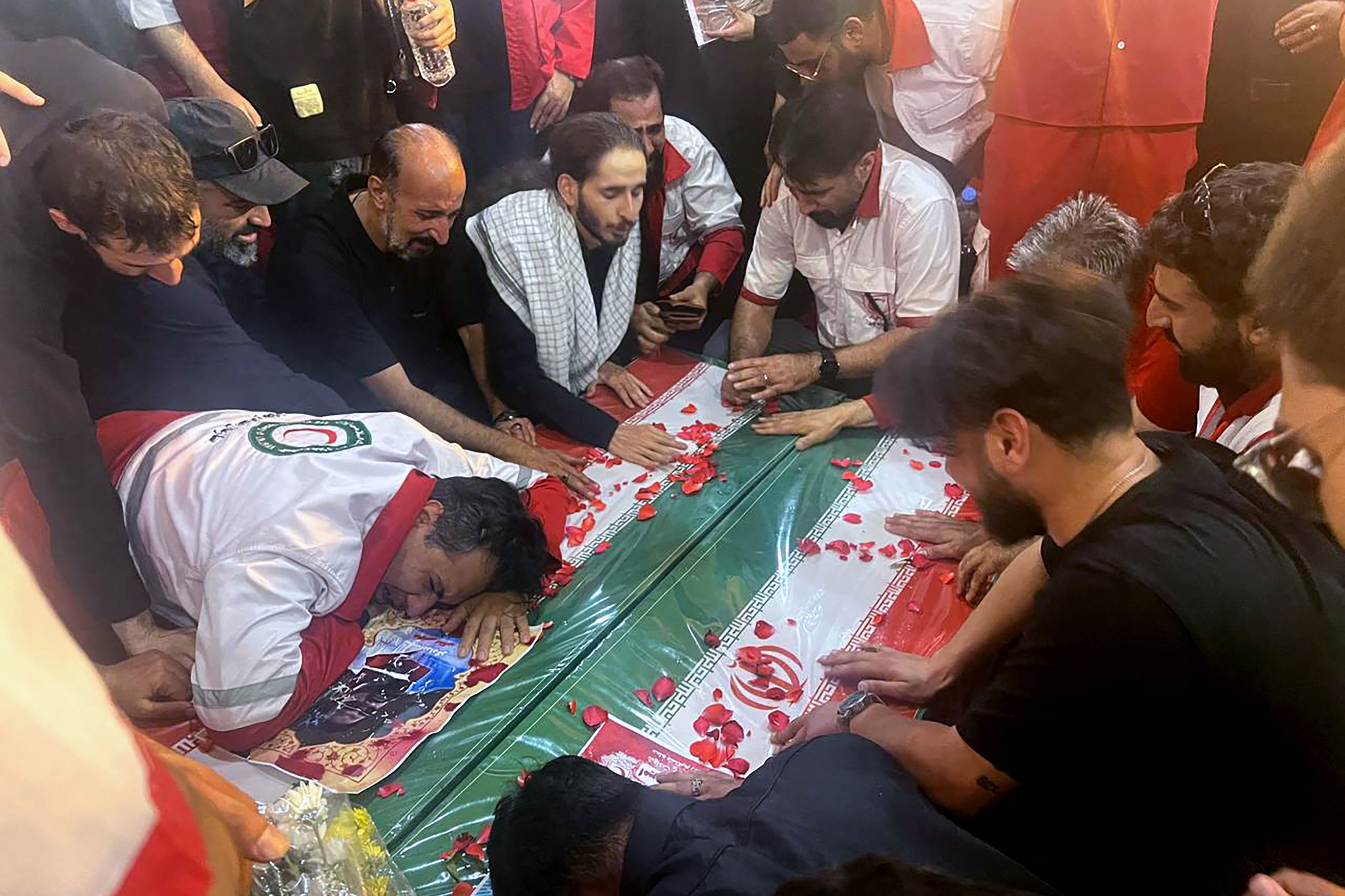 Mourners at a funeral draped in the Iranian flag.