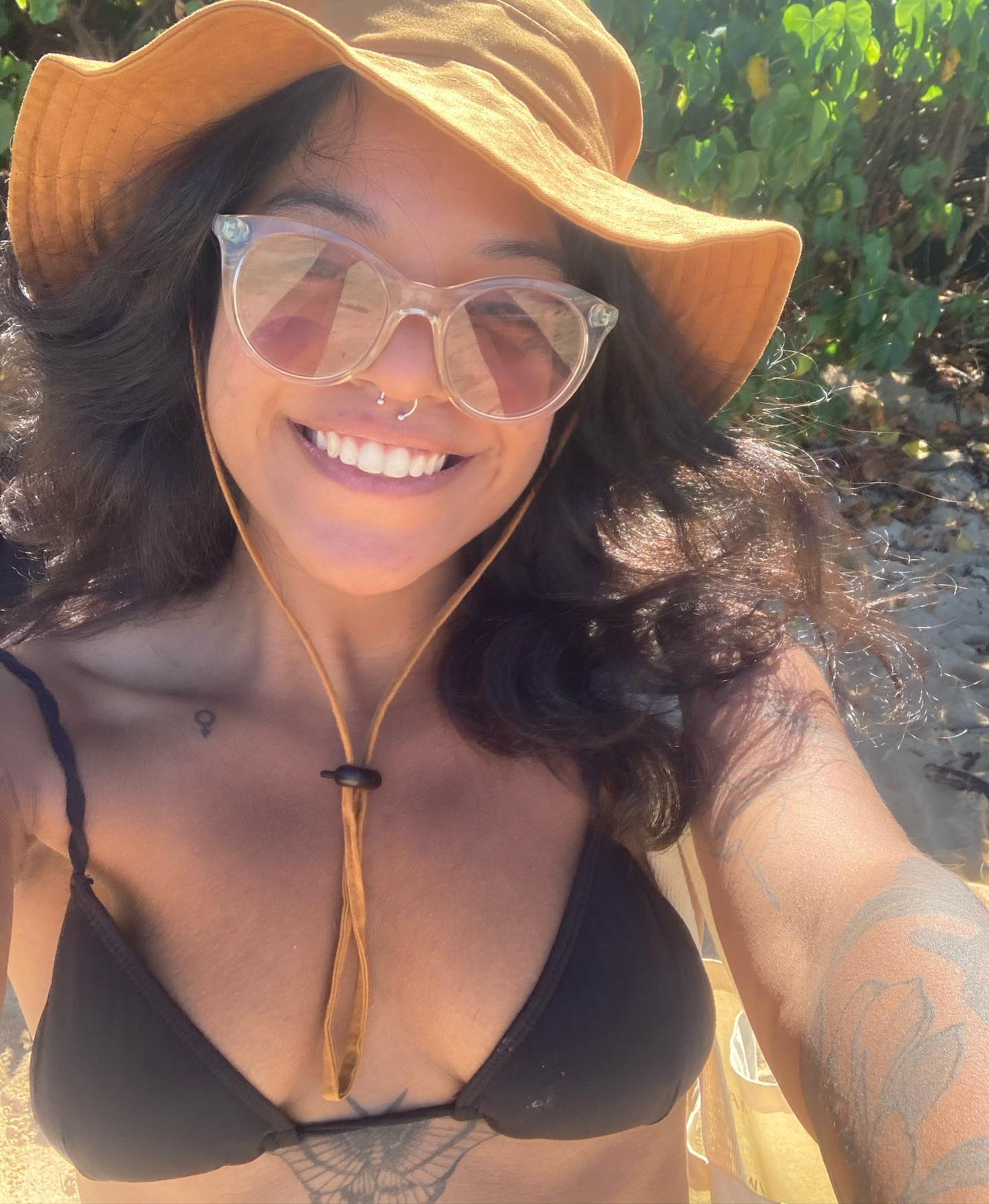 Selfie of a smiling young woman wearing a sun hat and sunglasses.