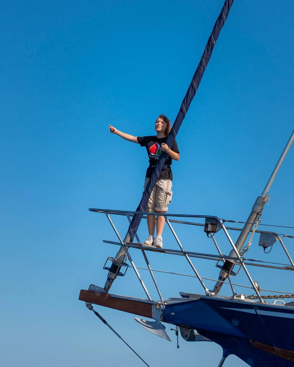Greta Thunberg on a boat, pointing.