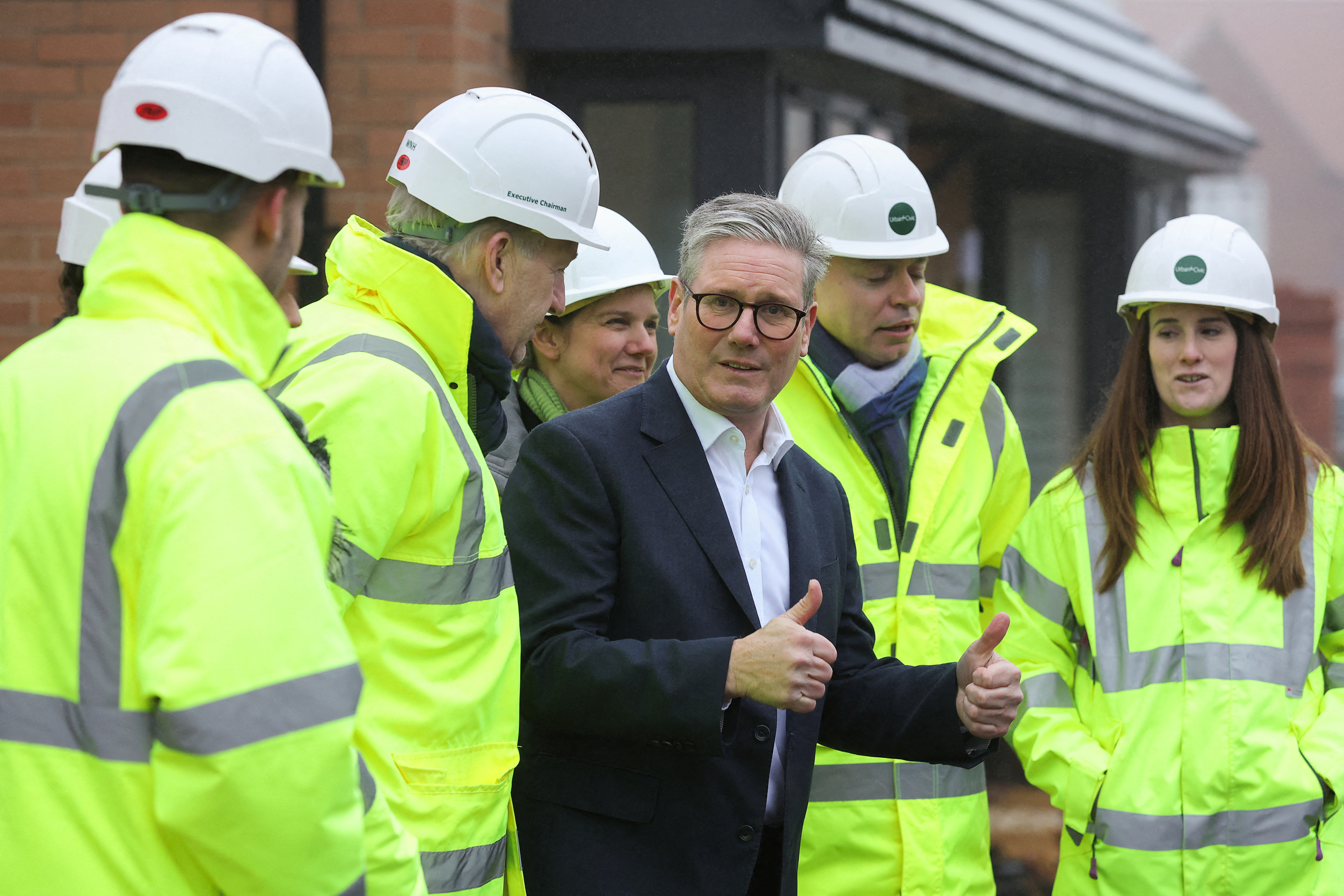 Prime Minister Keir Starmer giving a thumbs-up at a construction site.