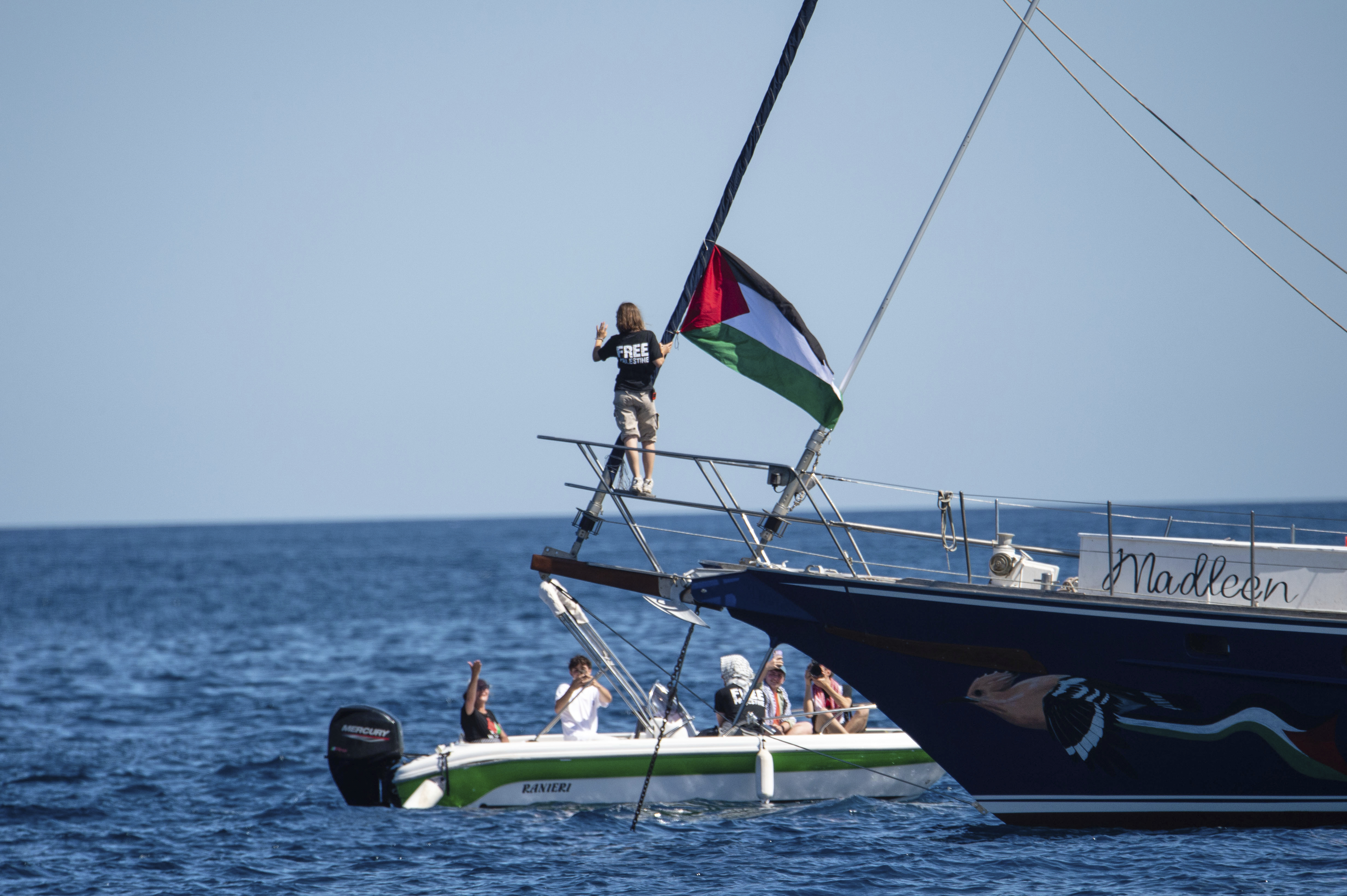 Greta Thunberg on a boat with a Palestinian flag, departing for Gaza.