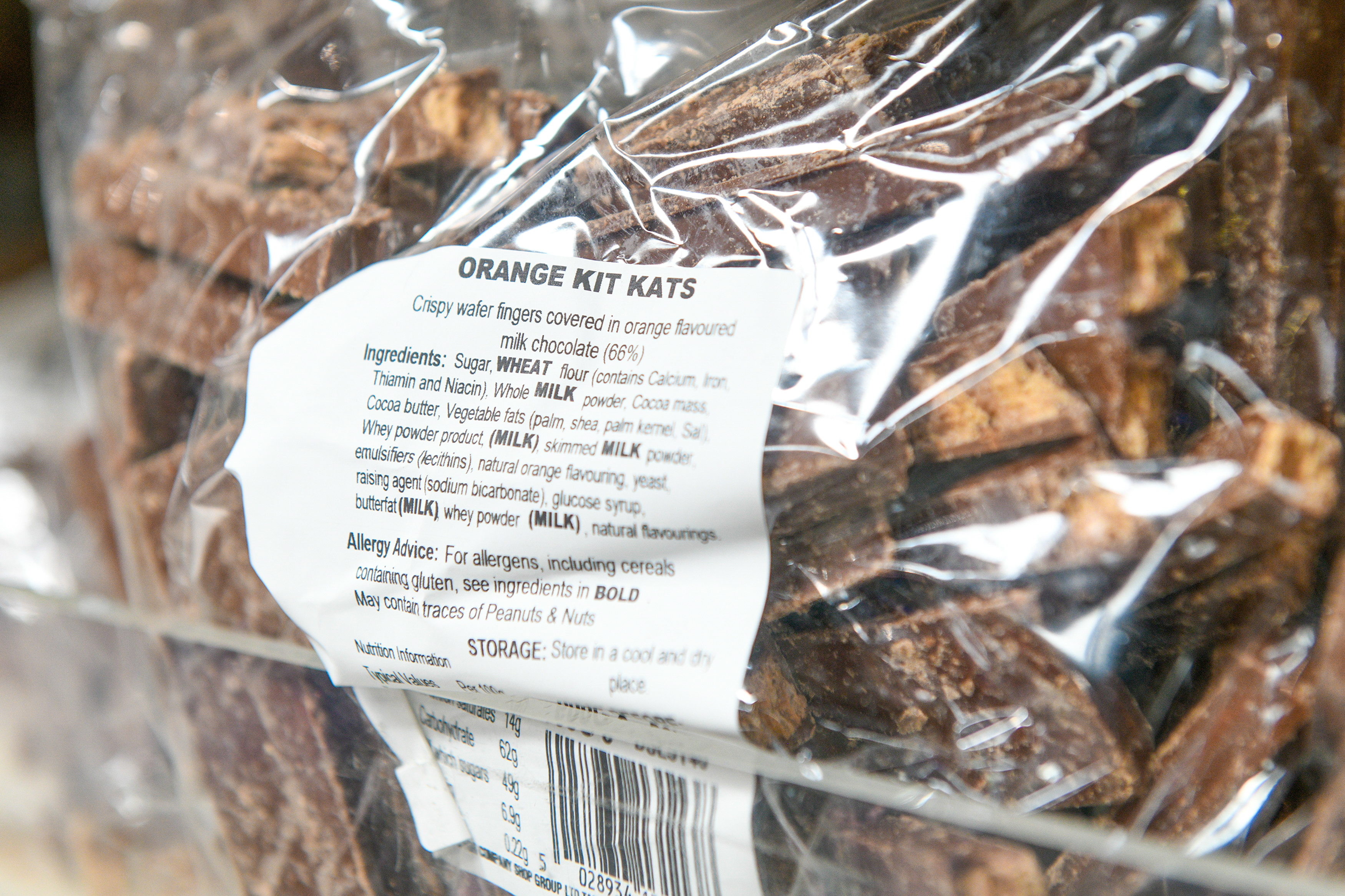 Close-up of a bag of orange-flavored Kit Kat pieces with ingredient label.