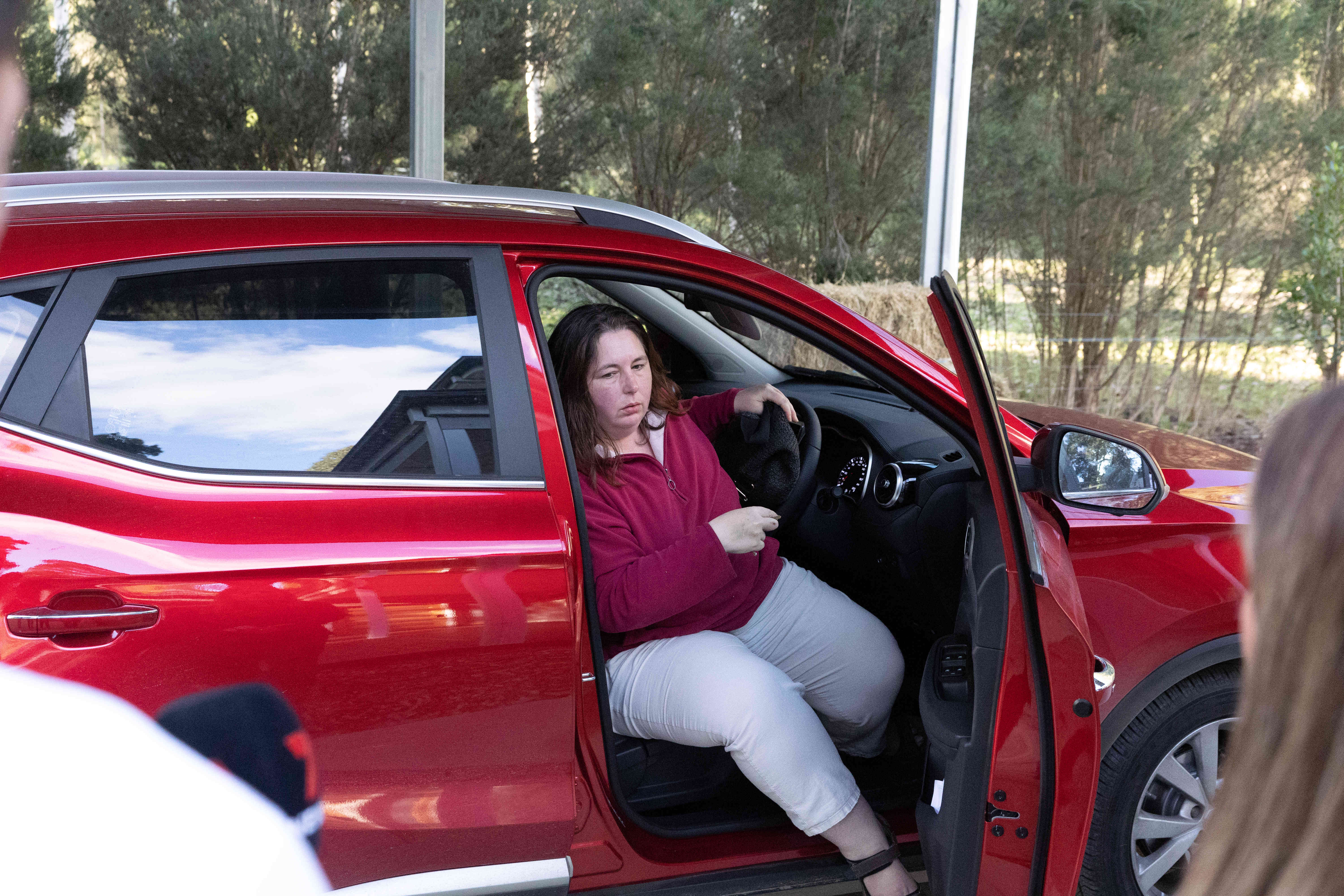 Erin Patterson sitting in a red car.