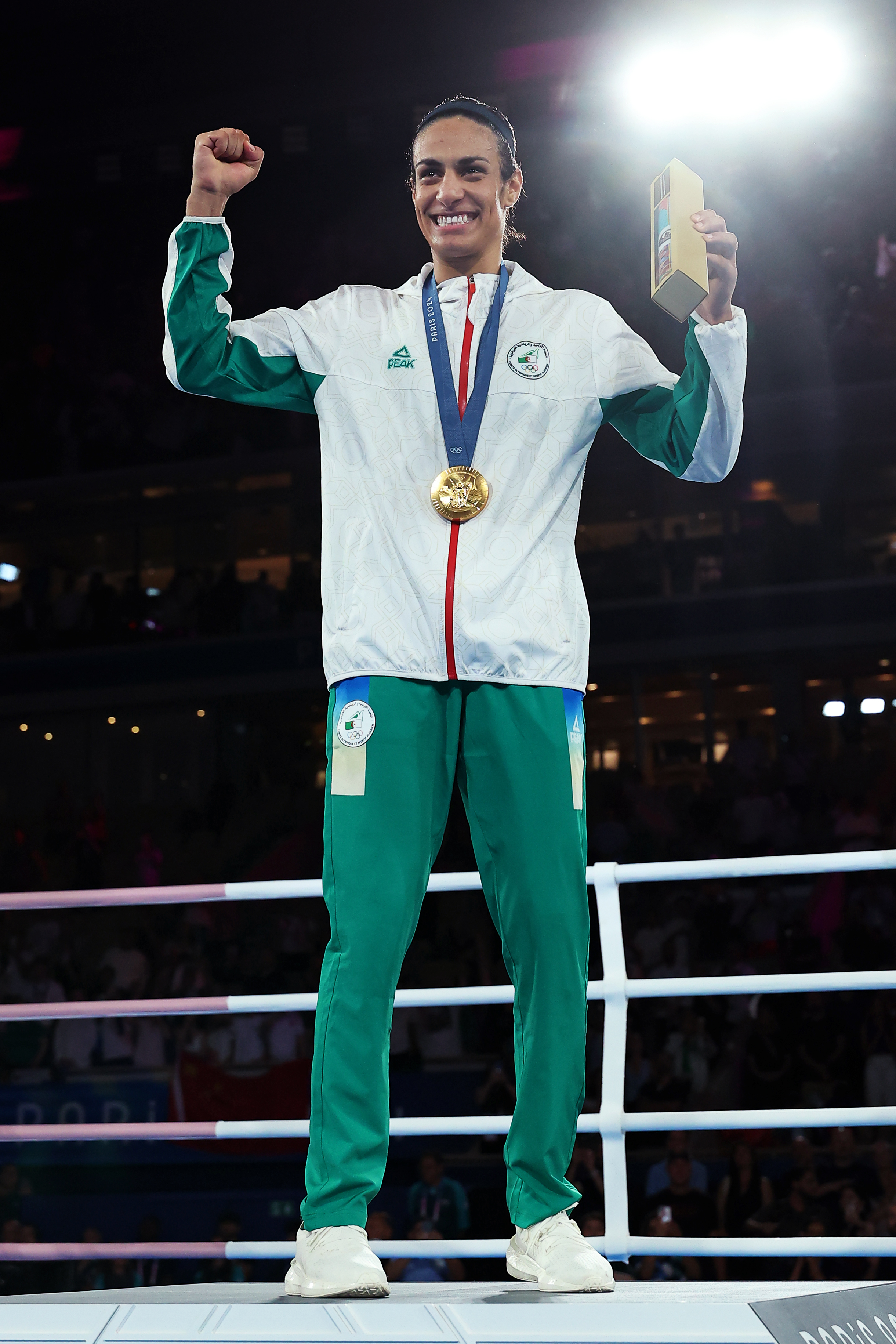 Algerian boxer Imane Khelif celebrates on the podium with her gold medal.