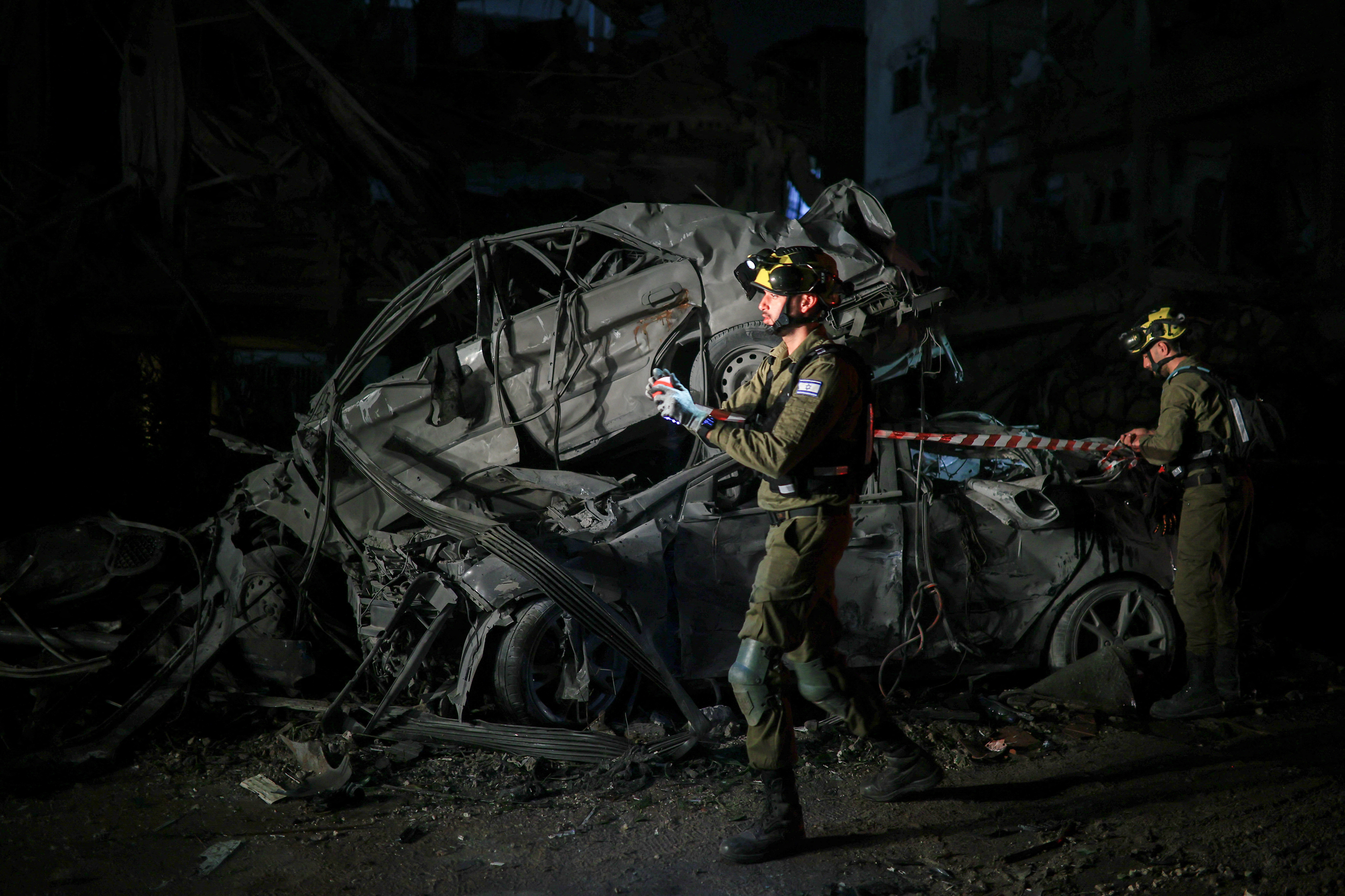 Rescue workers inspect the damage to cars after an Iranian missile in Ramat Gan, Israel on June 13, 2025. 
