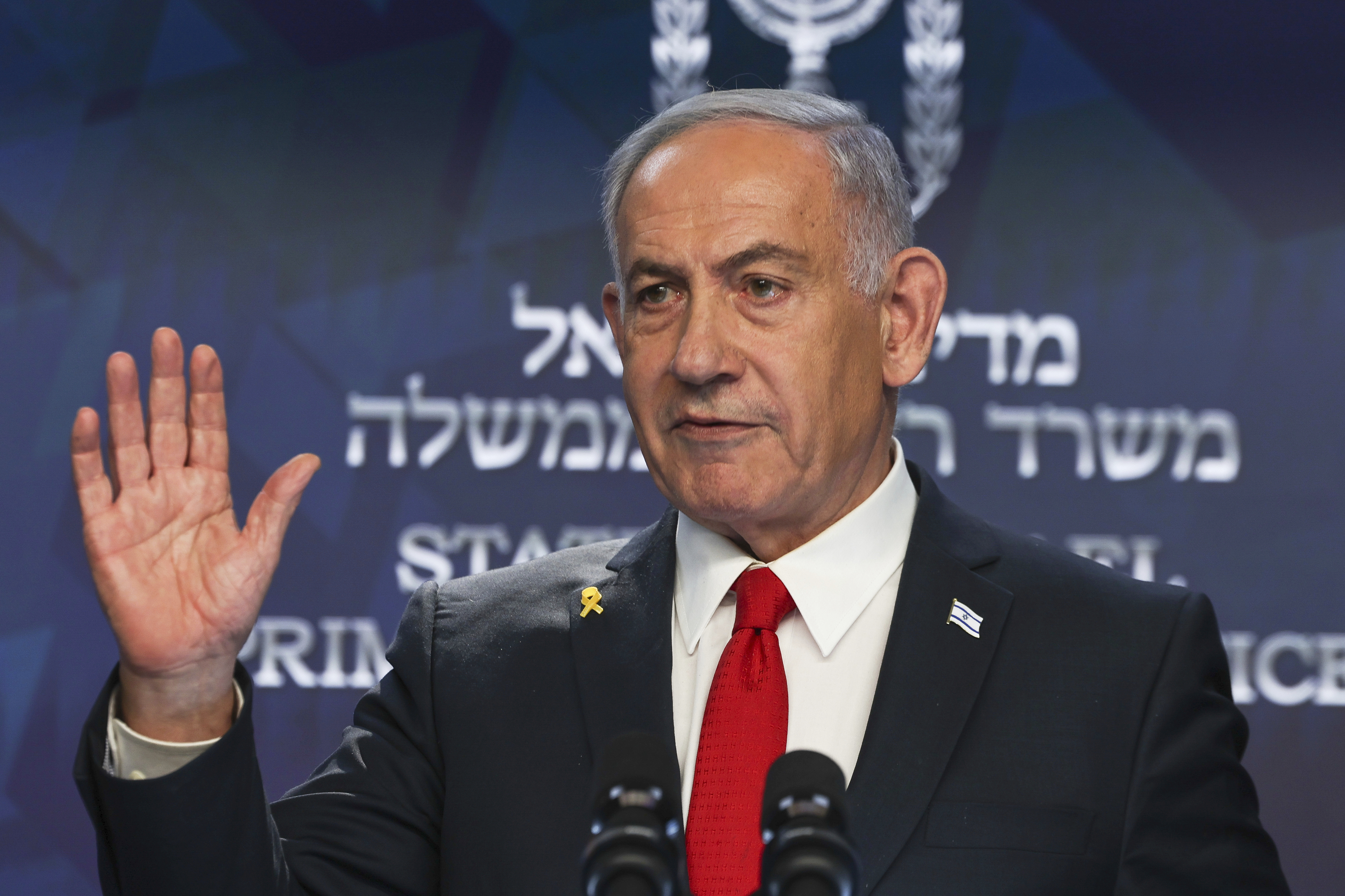 Benjamin Netanyahu waving at a press conference.