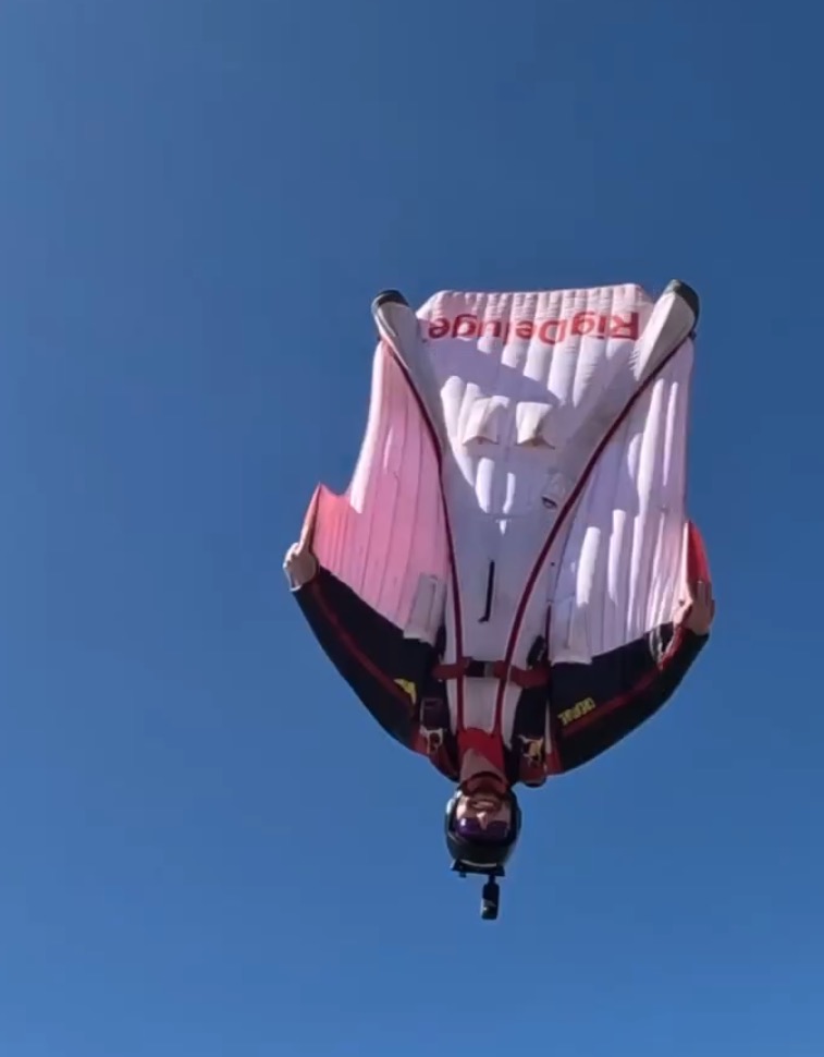 Wingsuit flier upside down in the air.