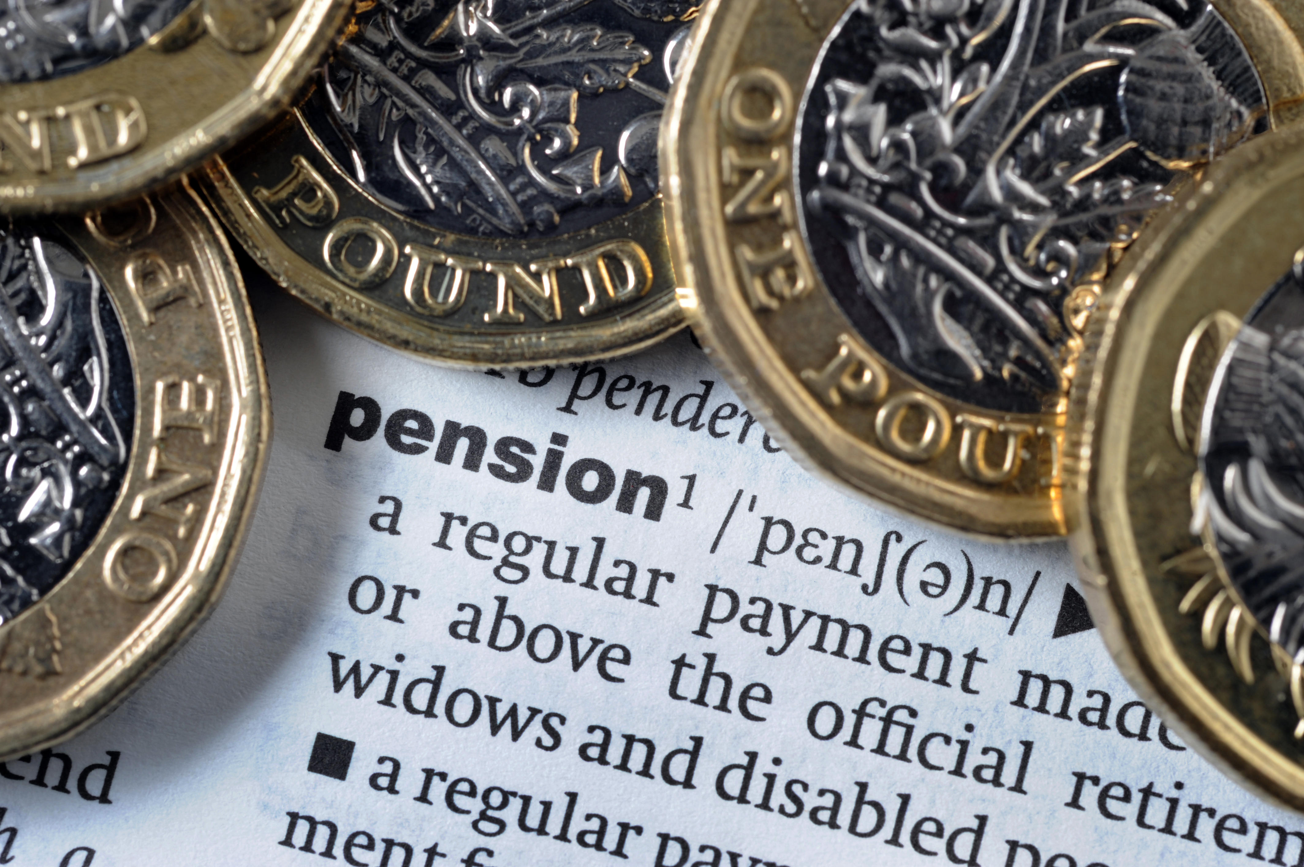 One pound coins on a dictionary page showing the definition of 