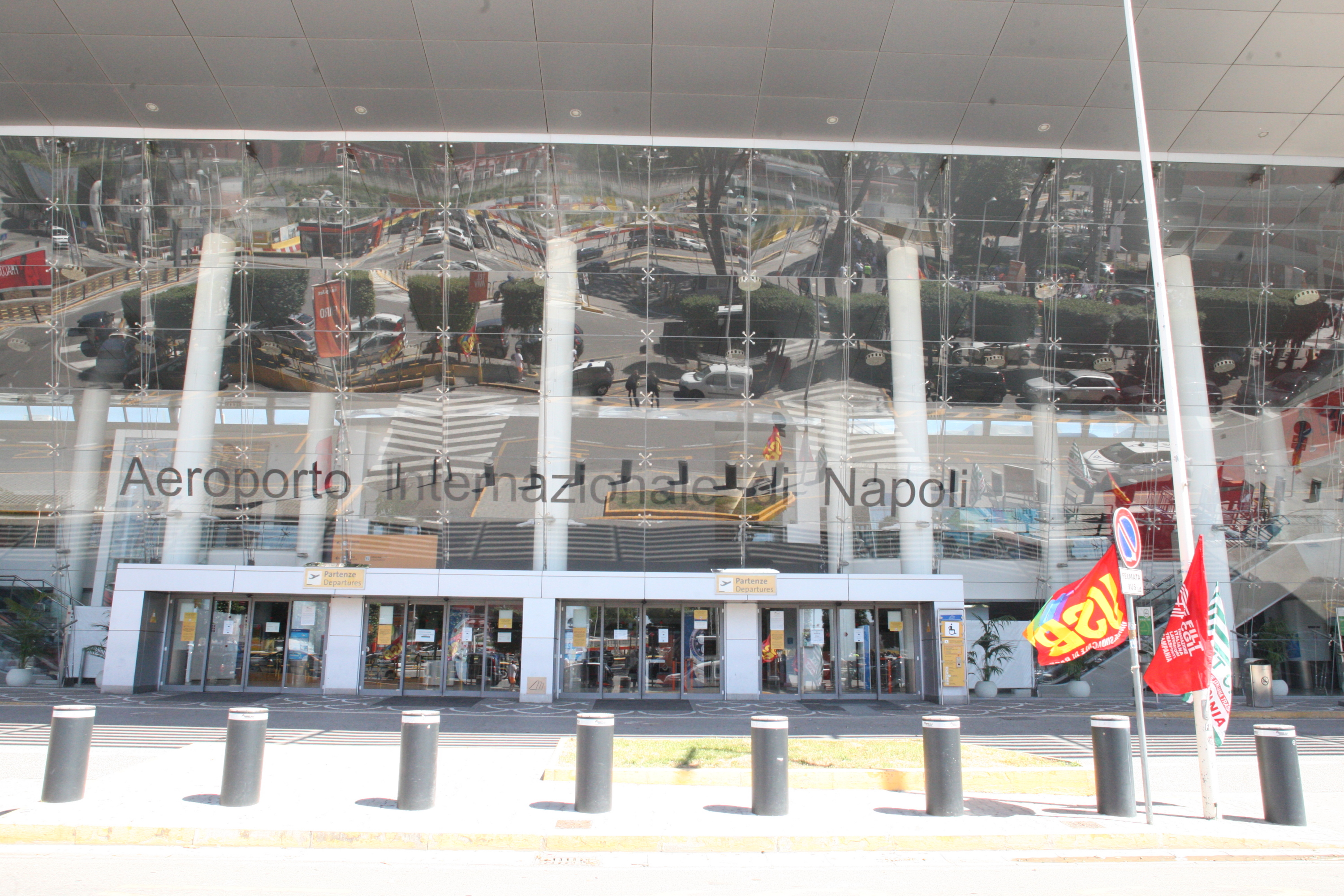 Protest at Naples International Airport entrance regarding job cuts.