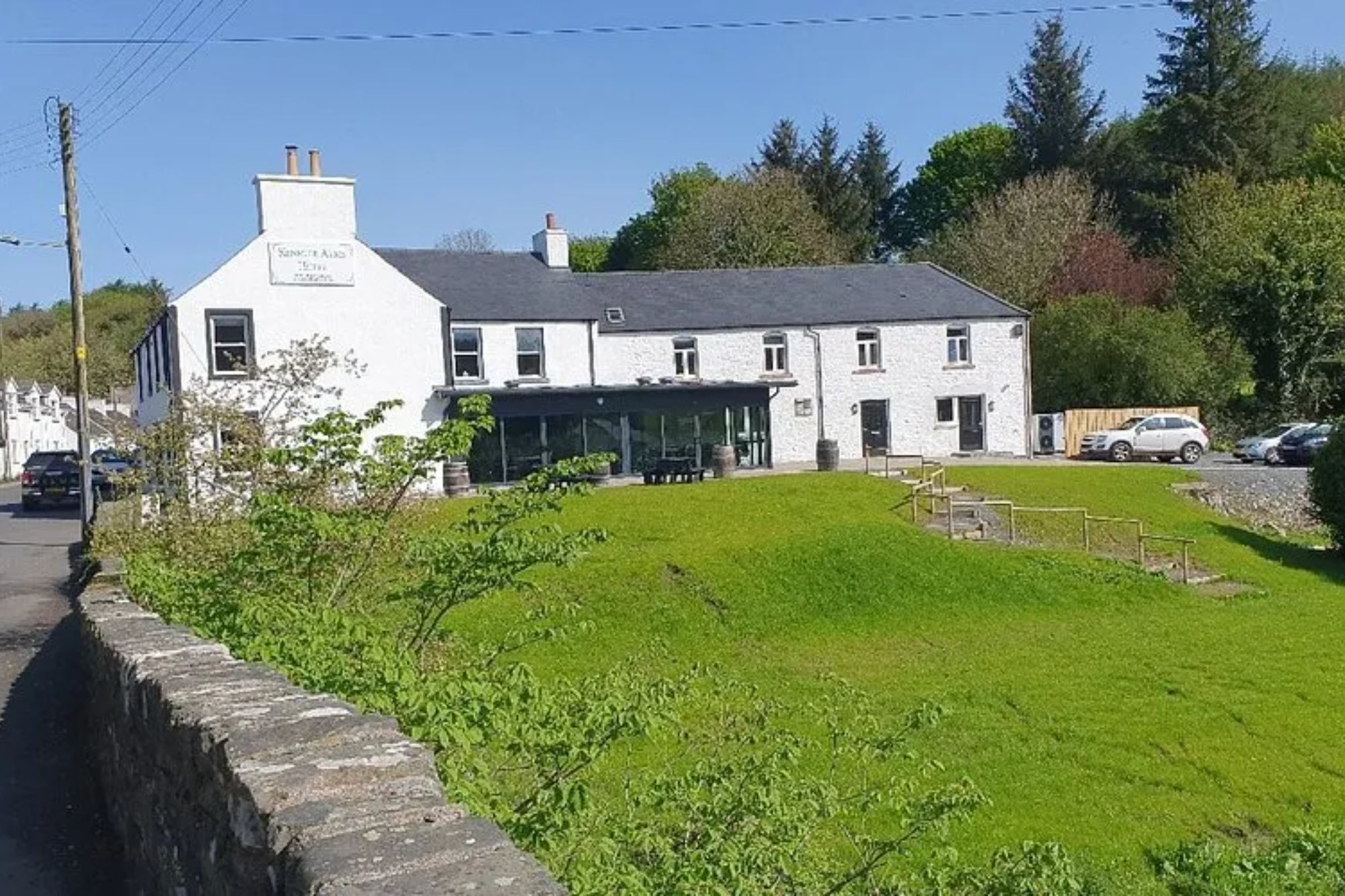 An image collage containing 1 images, Image 1 shows The Smuggler's Inn, a white building with a large grassy area in front