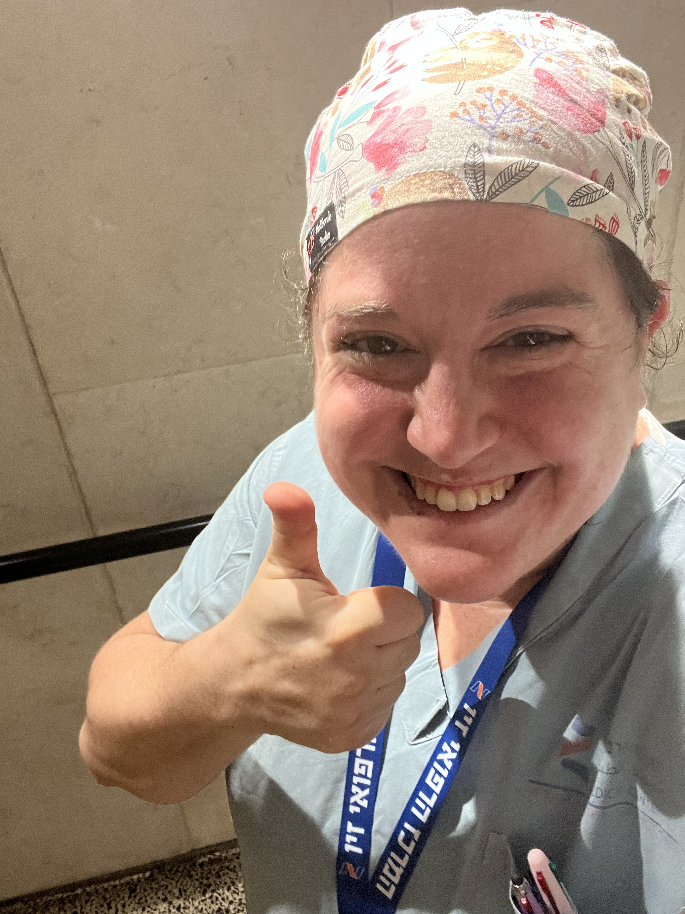 A smiling 36-year-old doctor gives a thumbs up.