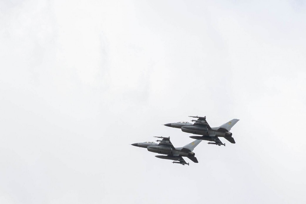 Two F-16 fighter jets in flight.