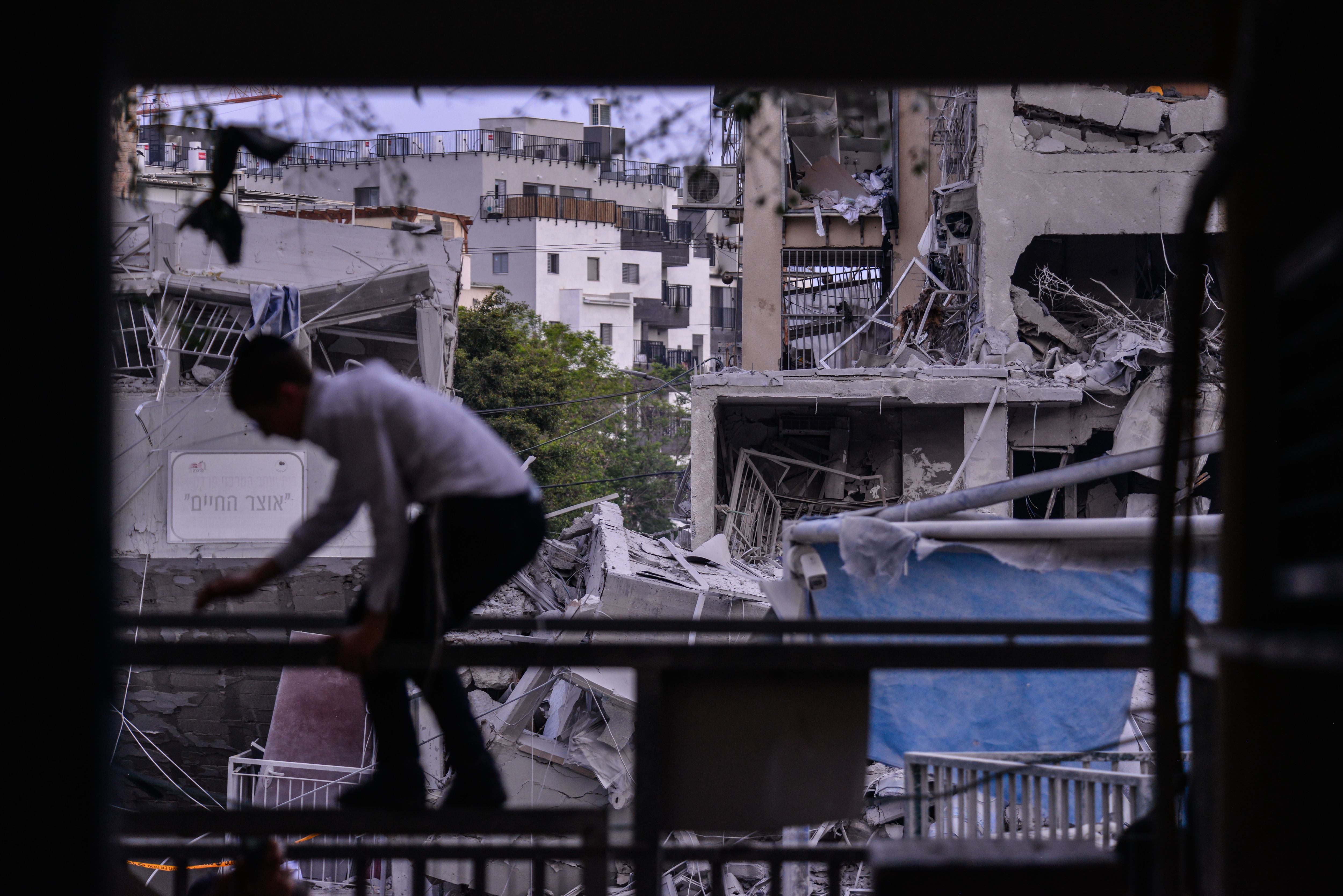 A boy walks past a building destroyed by a ballistic missile attack.