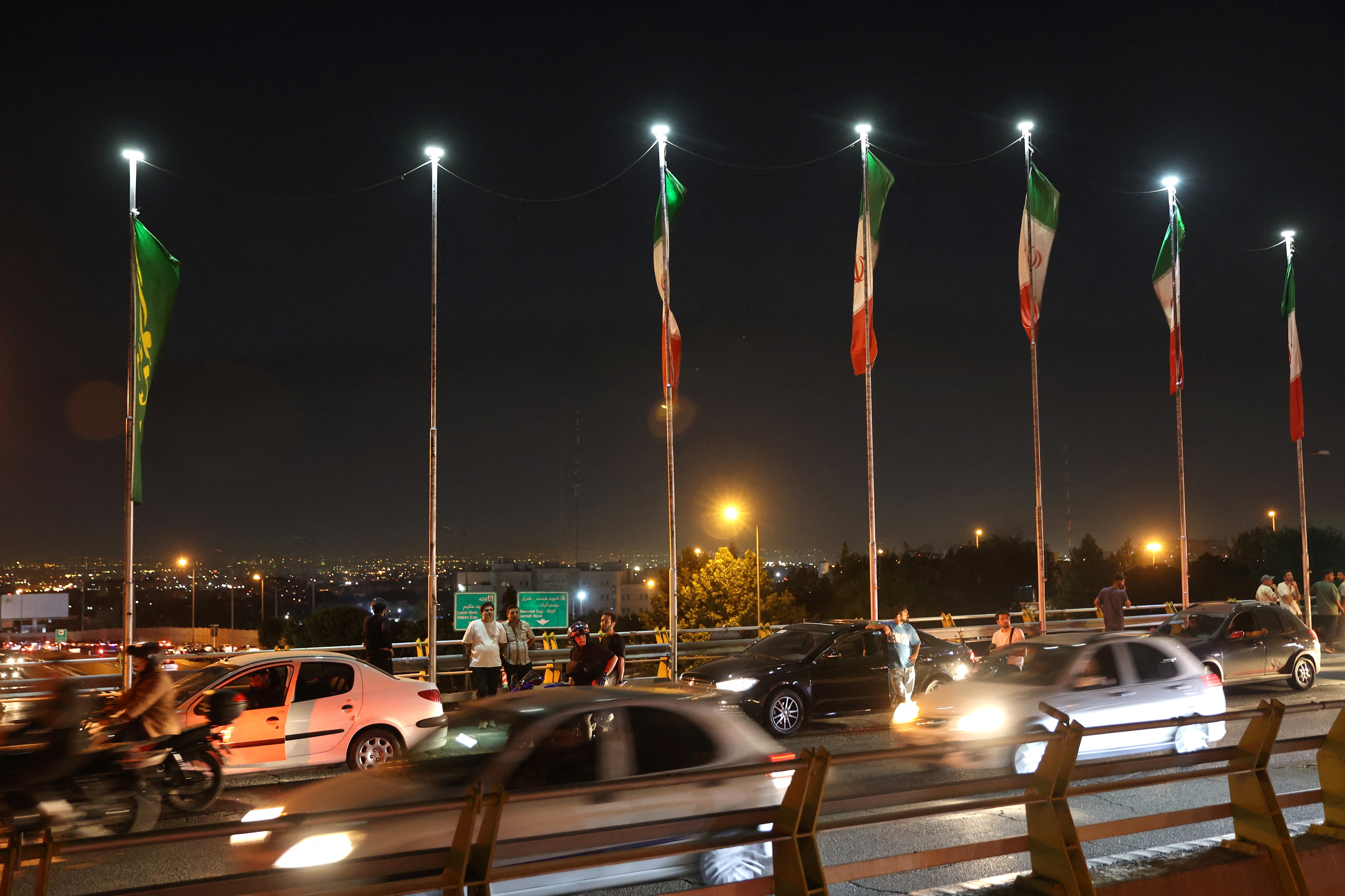 People gather in the street in the aftermath of Israeli strikes, in Tehran, Iran, June 15, 2025