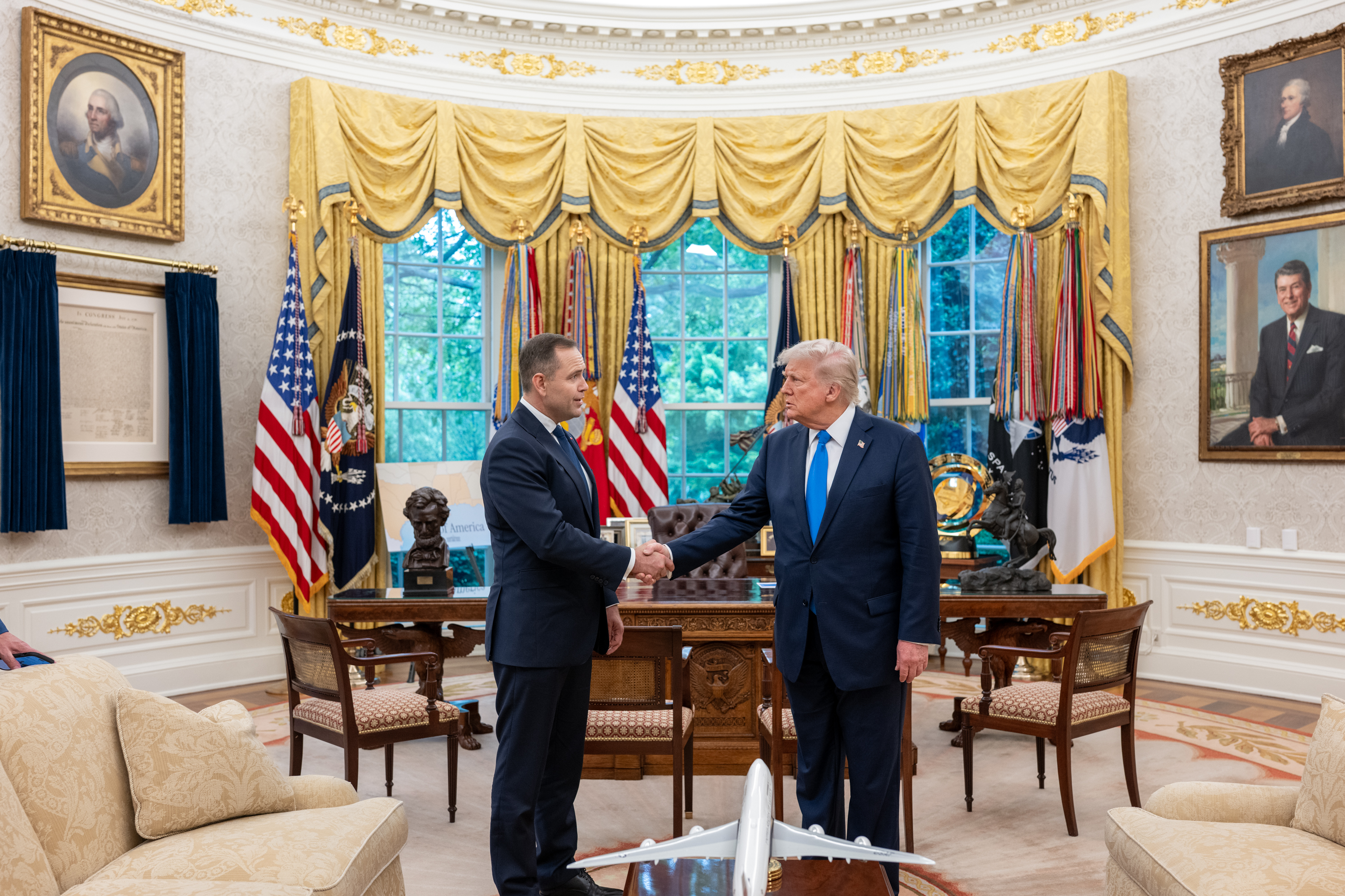 President Donald Trump shaking hands with Polish presidential candidate Karol Nawrocki in the Oval Office.