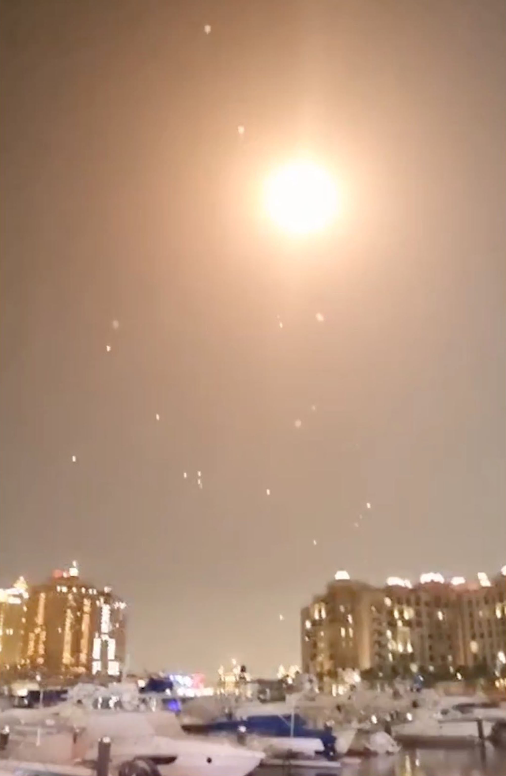 Intercepted missiles over a city at night.
