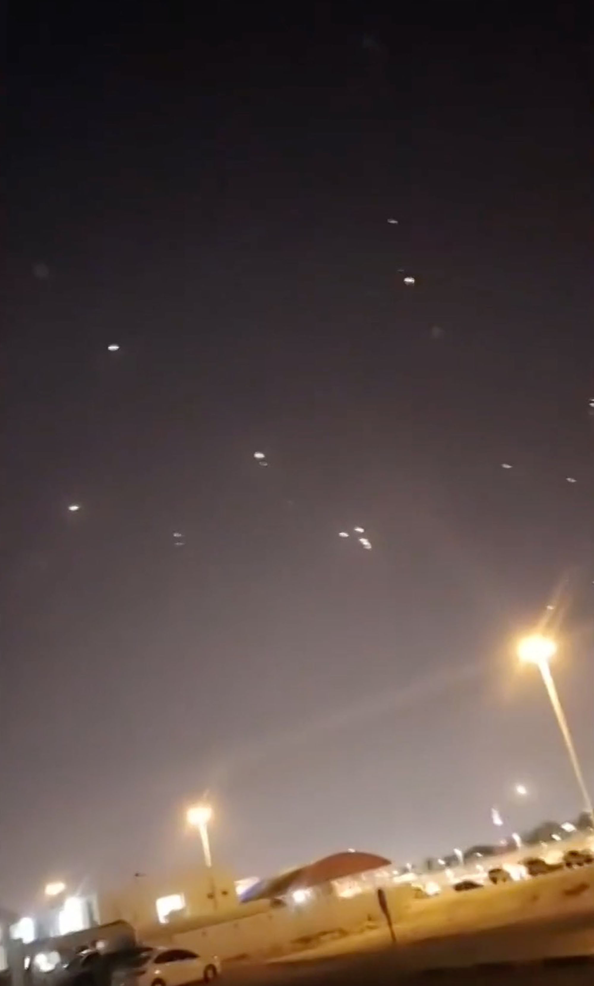Nighttime image of several lights in the sky over a city.