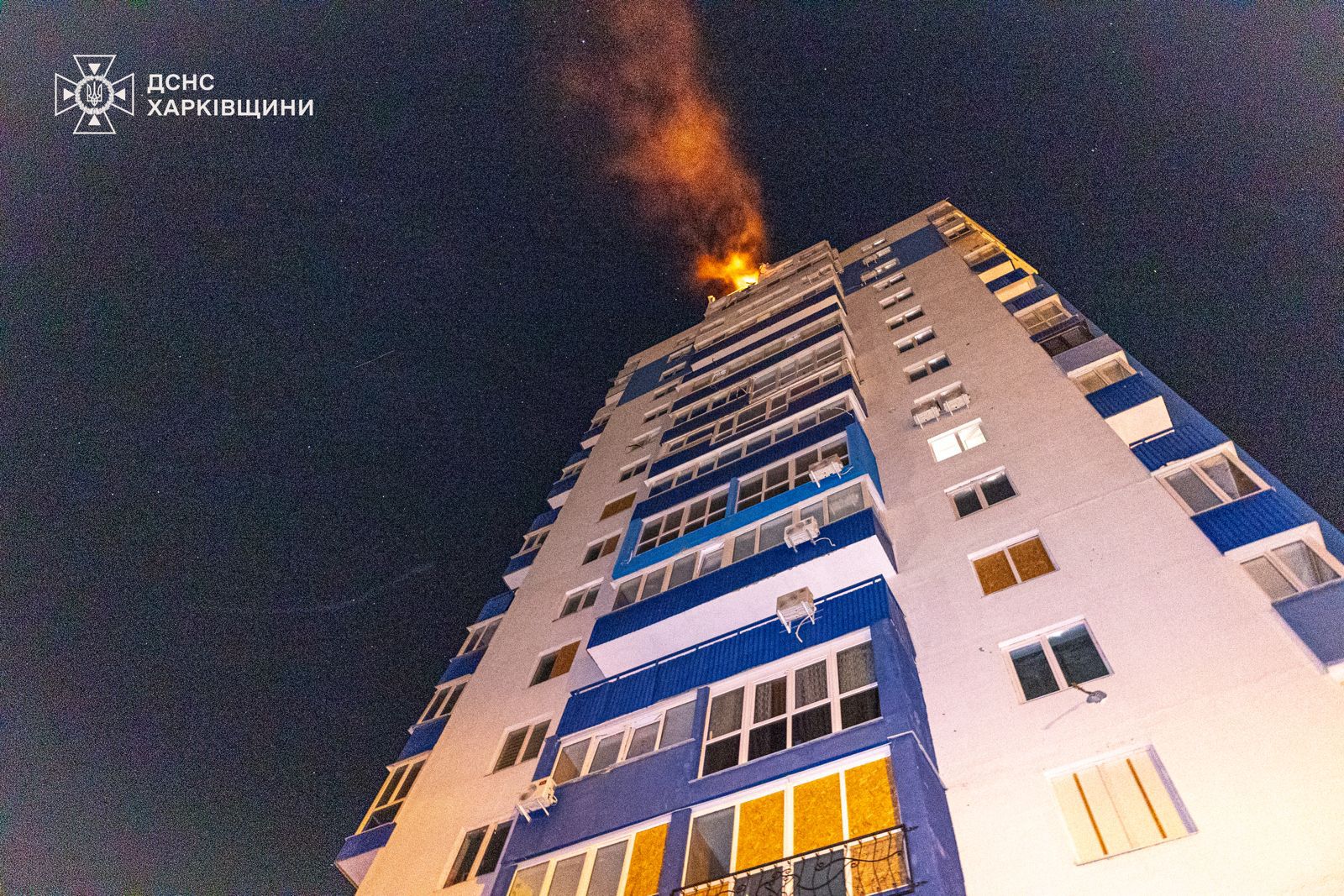 Flames shoot out the top of a Ukrainian apartment building after the deadly strike.