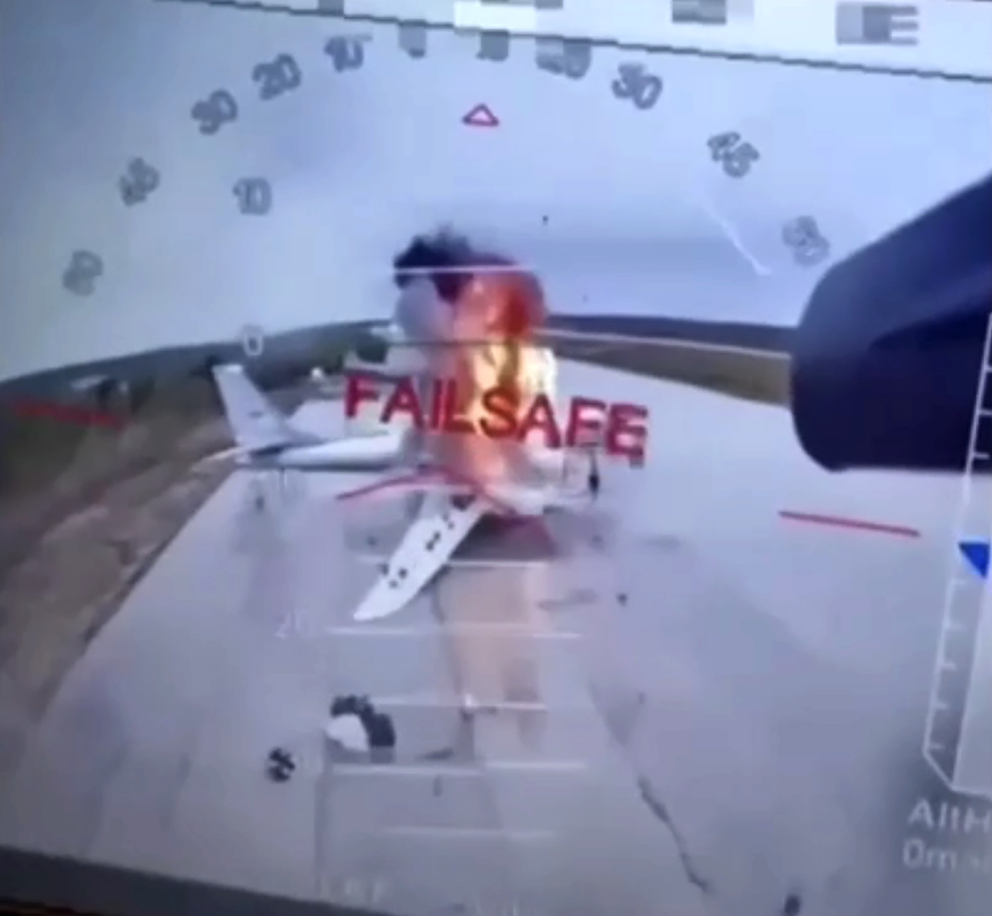 Screenshot of a drone video showing a plane on fire.