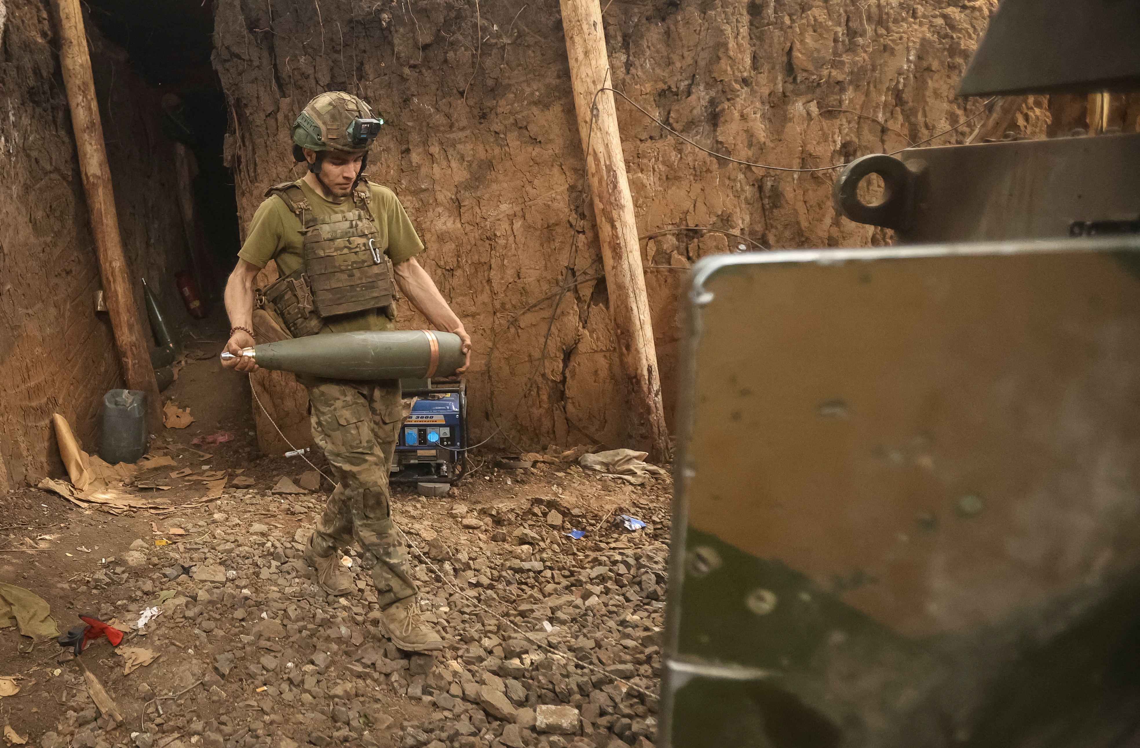 Ukrainian soldier carrying a howitzer shell near Toretsk.