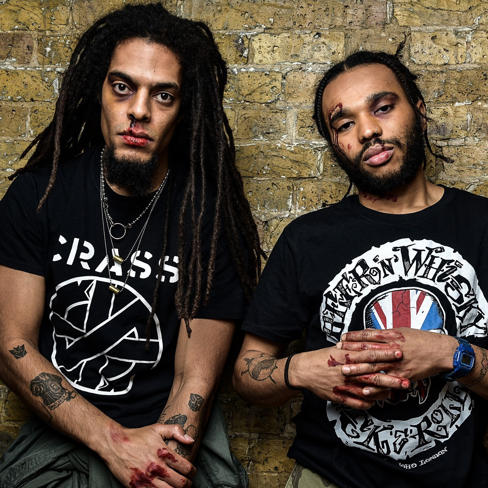 Portrait of Bob Vylan, a British band, with fake blood on their hands and faces.