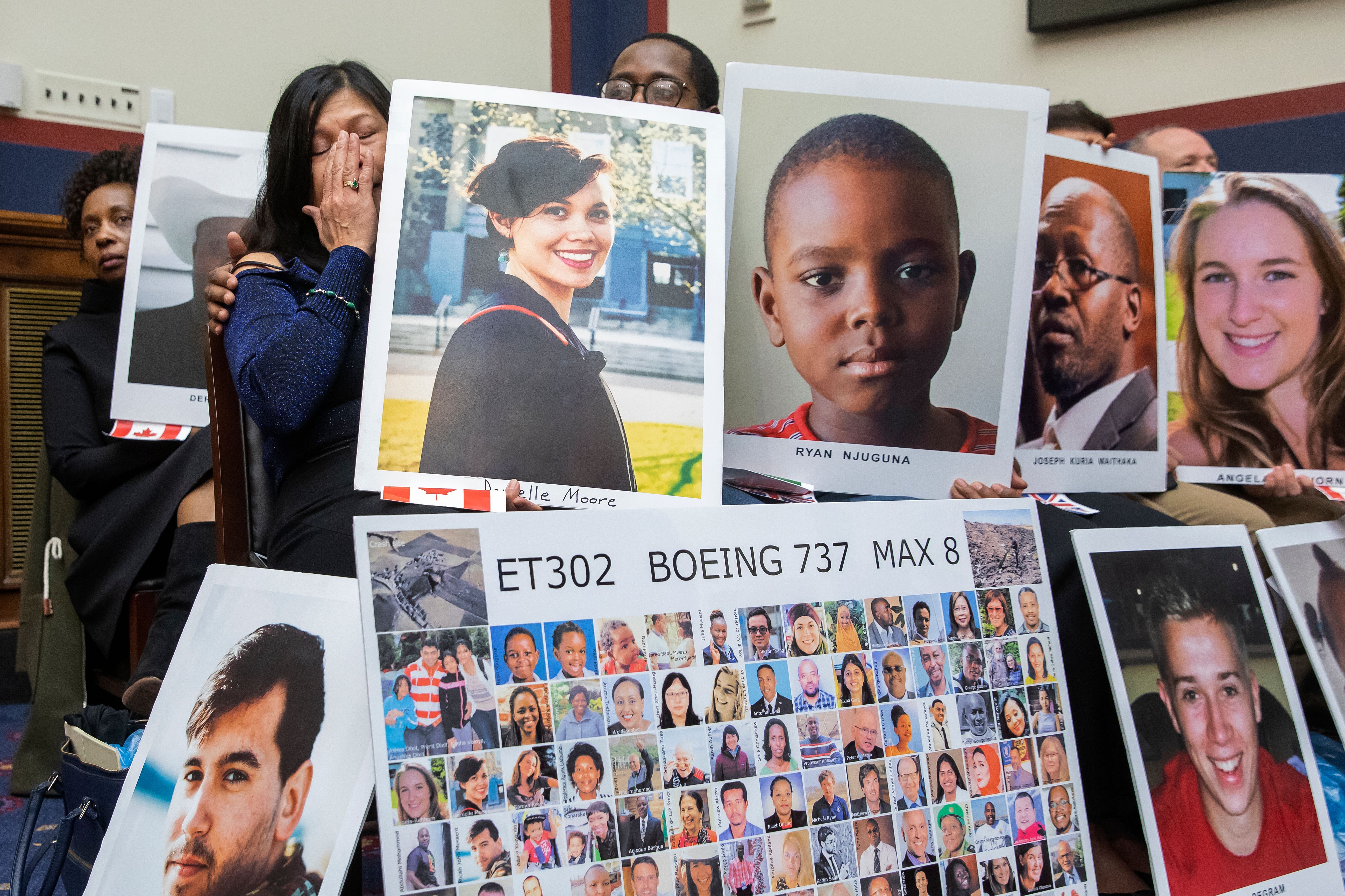 Photo of people holding photos of victims of the Boeing 737 MAX 8 crashes during a House Transportation Committee hearing.
