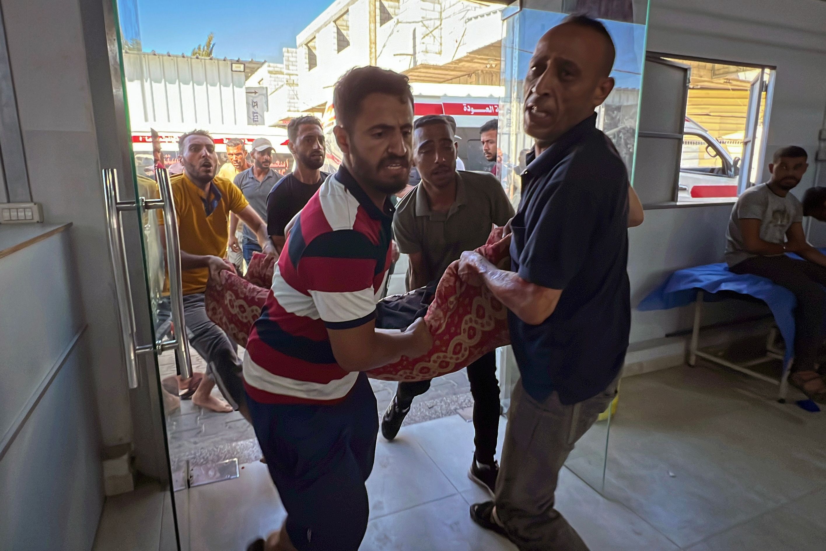 Palestinians carry casualties, including children, into Al-Awda Hospital in Nusairat, Gaza.