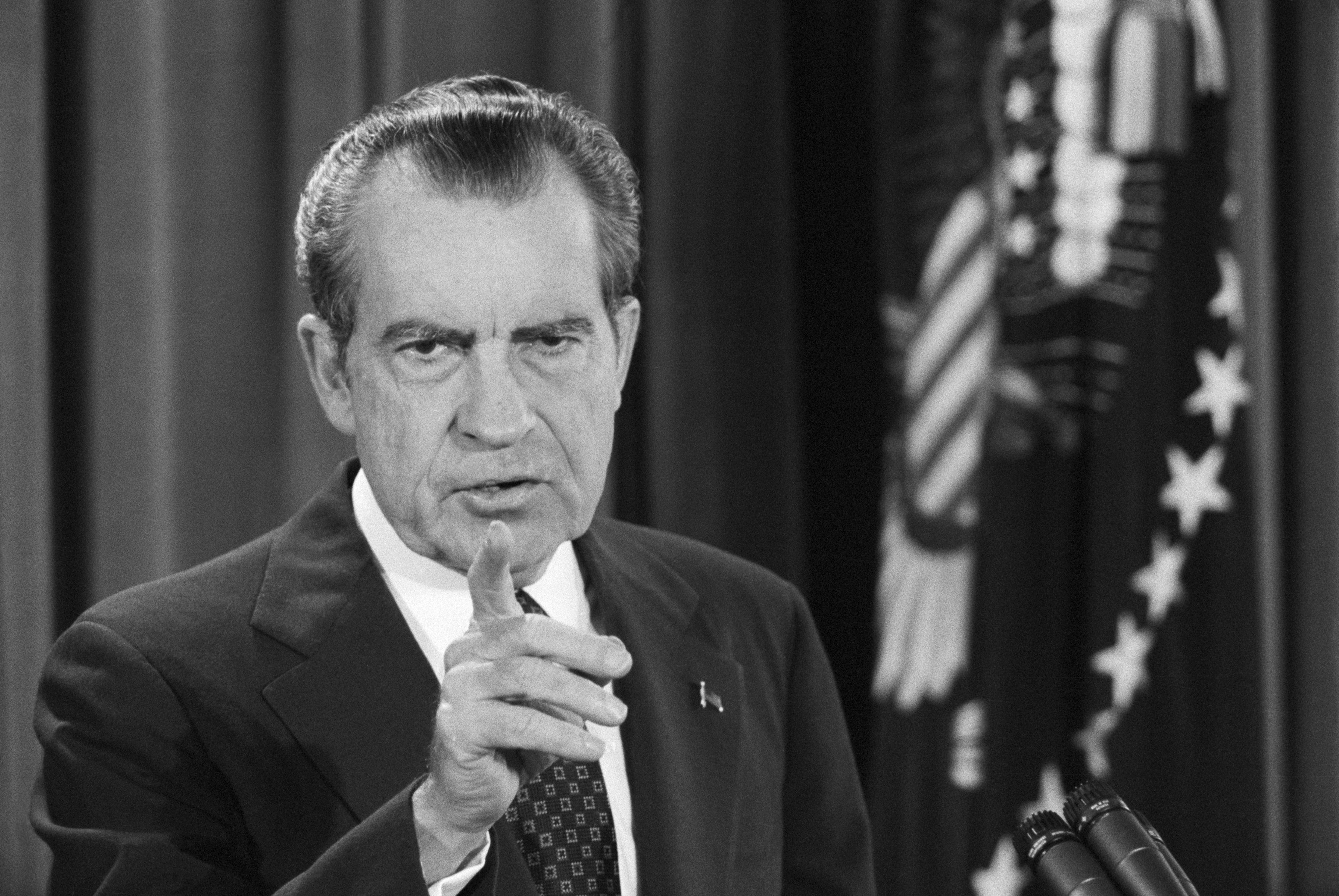 President Nixon points at a reporter.