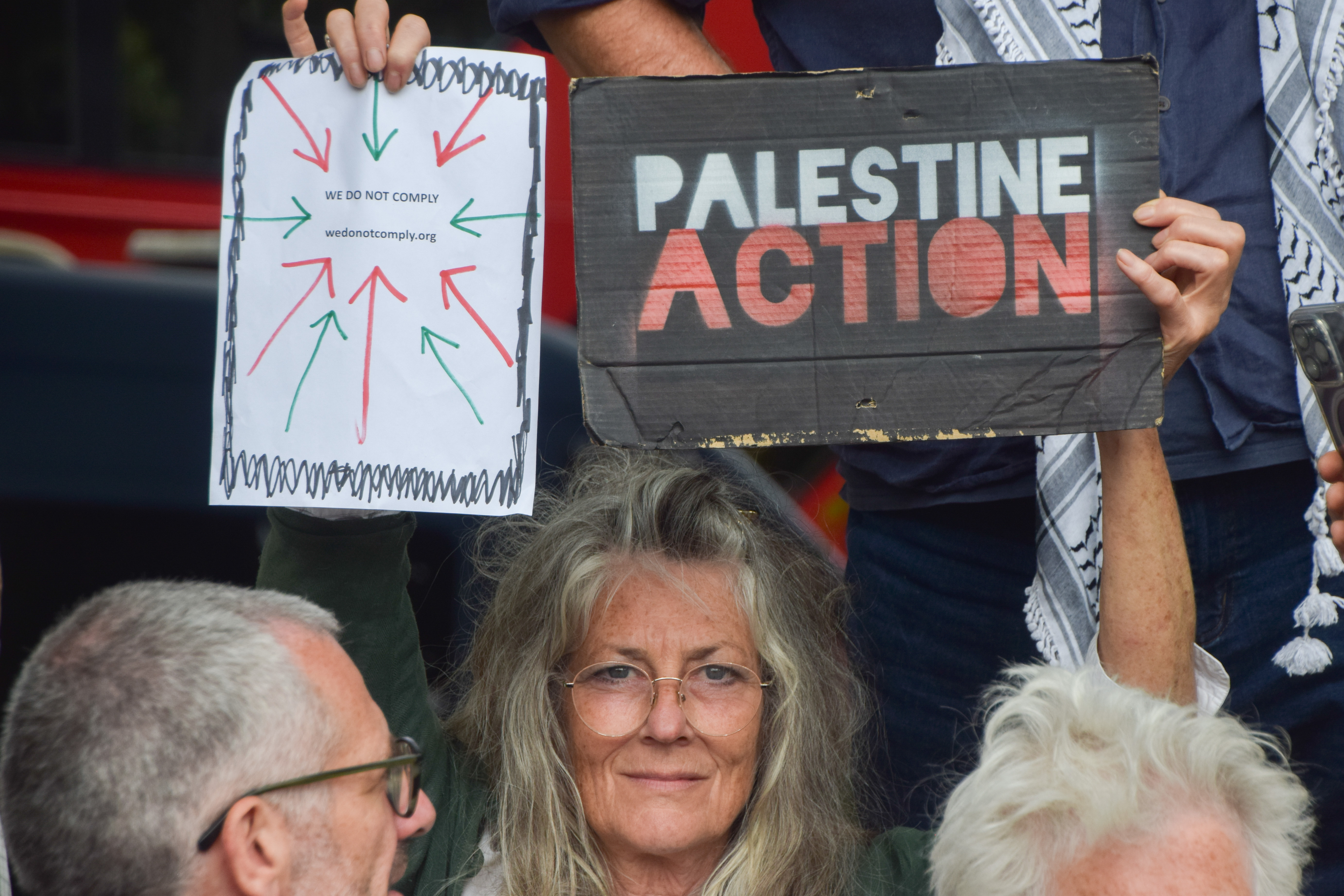 Protestors in Parliament Square holding signs supporting Palestine Action.
